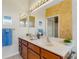 Well-lit bathroom with double sink vanity, large mirror, and neutral countertops at 2104 Batello Dr, Venice, FL 34292