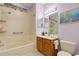 Relaxing bathroom features lavender walls, a combined shower and tub, and oak cabinet at 2104 Batello Dr, Venice, FL 34292