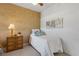 Small bedroom features a ceiling fan, leaf art, a white bed set, and bedside table at 2104 Batello Dr, Venice, FL 34292