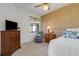 Cozy bedroom features patterned accent wall, a ceiling fan, and comfortable seating at 2104 Batello Dr, Venice, FL 34292