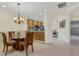 Dining room with glass table adjacent to a kitchen with granite counters and stainless appliances at 2104 Batello Dr, Venice, FL 34292