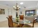 Charming dining room features a glass-top table, comfortable seating, and view to screened patio at 2104 Batello Dr, Venice, FL 34292