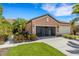 Exterior shot of the two car garage with beautiful landscaping and a screened garage door at 2104 Batello Dr, Venice, FL 34292