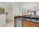 Kitchen area with granite countertops, a stainless steel dishwasher, and views of the dining room at 2104 Batello Dr, Venice, FL 34292
