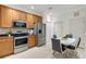Well-equipped kitchen with wooden cabinets, stainless steel appliances and a cozy breakfast nook at 2104 Batello Dr, Venice, FL 34292