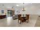 Inviting living room with dining area, neutral tones, tiled floor, and access to outdoor patio at 2104 Batello Dr, Venice, FL 34292