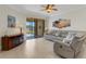 Bright and airy living room with tile flooring, a leather couch set and a sliding door that leads to the porch at 2104 Batello Dr, Venice, FL 34292