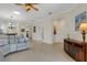 Open living room with tile floors, neutral walls, ceiling fan, and comfortable seating arrangement at 2104 Batello Dr, Venice, FL 34292