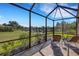 Scenic screened-in patio with a tranquil water view, lounge chairs, and beautiful landscaping at 2104 Batello Dr, Venice, FL 34292