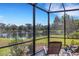 Serene screened-in lanai overlooking a peaceful pond, complete with comfortable lounge chairs and lush greenery at 2104 Batello Dr, Venice, FL 34292