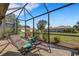 Inviting screened-in lanai with tile flooring and cozy lounge chairs, offering serene outdoor living space at 2104 Batello Dr, Venice, FL 34292