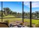 Secluded screened-in patio with a lovely pond view, offering relaxation and privacy with comfortable seating at 2104 Batello Dr, Venice, FL 34292