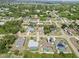 Aerial view displays neighborhood showcasing mature trees, community layout, and tranquil lake backdrop at 219 Capatola St, Port Charlotte, FL 33948