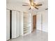 Bright bedroom with tile floors, a ceiling fan, and a bookshelf next to closet at 219 Capatola St, Port Charlotte, FL 33948