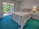 Bedroom featuring a sliding glass door to the lanai, patterned comforter, and green carpet at 2194 Abalom St, Punta Gorda, FL 33980