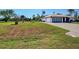 Spacious home featuring a two-car garage, a paved driveway, and a sizable front yard at 2194 Abalom St, Punta Gorda, FL 33980