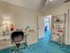 Cozy home office featuring a glass desk, shelving, and bright blue carpeting at 2194 Abalom St, Punta Gorda, FL 33980