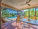 Relaxing screened patio with ceiling fan, table, and chairs overlooking the sparkling pool and lush backyard at 2194 Abalom St, Punta Gorda, FL 33980