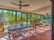 Comfortable screened patio offers beautiful green backyard views, ceiling fan, and tiled floor at 2194 Abalom St, Punta Gorda, FL 33980