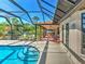 Relaxing enclosed pool area featuring an outdoor dining area and lush landscaping at 2194 Abalom St, Punta Gorda, FL 33980