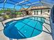 Well-maintained enclosed pool featuring a spacious deck and lush landscaping, perfect for relaxation at 2194 Abalom St, Punta Gorda, FL 33980