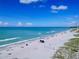 Aerial view of Venice Beach, blue green waters, beachgoers, lifeguard station, white sand at 232 Saint Augustine Ave # 701, Venice, FL 34285