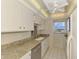 Well-lit kitchen with white appliances, granite countertops, and a ceiling fan at 232 Saint Augustine Ave # 701, Venice, FL 34285