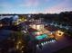 Stunning aerial view of a property featuring a screened pool, dock, and a rooftop deck at twilight at 2322 Bayshore Rd, Nokomis, FL 34275