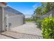 View of the backyard through a white metal gate, lush greenery visible at 2322 Bayshore Rd, Nokomis, FL 34275