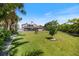 Large lush backyard with brick paved area and home featuring a rooftop deck at 2322 Bayshore Rd, Nokomis, FL 34275