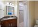 Bathroom vanity featuring dark cabinets, granite countertops, a sink, and a tiled walk-in shower at 2322 Bayshore Rd, Nokomis, FL 34275