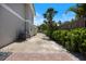 Side driveway features rock base, green hedges, privacy fence, and access gate at 2322 Bayshore Rd, Nokomis, FL 34275