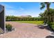 Brick driveway leading to a green backyard with palms, a house, and a sunny blue sky at 2322 Bayshore Rd, Nokomis, FL 34275