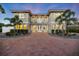 Charming home featuring a red tile roof, symmetrical design, and paved driveway, set against a twilight sky at 2322 Bayshore Rd, Nokomis, FL 34275