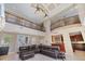 Spacious living room with soaring ceilings, balcony overlook, comfortable leather seating, and open kitchen at 2322 Bayshore Rd, Nokomis, FL 34275