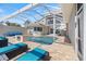 Screened in pool and patio area with outdoor kitchen, lounge chairs, and seating at 2322 Bayshore Rd, Nokomis, FL 34275