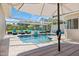Outdoor pool and patio area with covered seating, lounge chairs, and privacy fence at 2322 Bayshore Rd, Nokomis, FL 34275