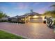 Well-lit rear exterior features screened-in pool, patio, and brick-paved driveway at 2322 Bayshore Rd, Nokomis, FL 34275