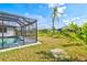 A relaxing backyard with a screen enclosed pool area and lush tropical landscaping provides a serene oasis at 269 Mark Twain Ln, Rotonda West, FL 33947