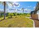 An expansive lawn and lush tropical landscaping accent the fenced backyard with screened in pool at 269 Mark Twain Ln, Rotonda West, FL 33947
