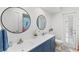 Bright bathroom with double sinks, vanity, blue cabinets, and decorative accents at 269 Mark Twain Ln, Rotonda West, FL 33947