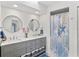 Bright bathroom with double sinks, vanity, and shower with decorative curtain at 269 Mark Twain Ln, Rotonda West, FL 33947