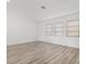 Bright bedroom featuring three windows and sleek, modern wood laminate flooring at 269 Mark Twain Ln, Rotonda West, FL 33947
