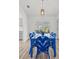 Bright dining area with blue wicker furniture, light wood floors, and view to the patio at 269 Mark Twain Ln, Rotonda West, FL 33947