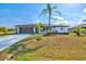 Charming single-story home featuring a well-maintained lawn, palm trees, and a two-car garage at 269 Mark Twain Ln, Rotonda West, FL 33947