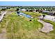 Aerial shot of a golf course with a scenic water feature, showcasing the community's beautiful recreational space at 269 Mark Twain Ln, Rotonda West, FL 33947