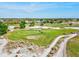 Scenic aerial view of the golf course with lush green fairways and sand traps under a clear blue sky at 269 Mark Twain Ln, Rotonda West, FL 33947