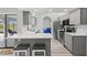 Kitchen featuring gray cabinets, stainless appliances, breakfast bar, and dining area at 269 Mark Twain Ln, Rotonda West, FL 33947