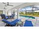 Covered patio area with a refreshing swimming pool, lounging furniture and manicured yard for outdoor entertainment at 269 Mark Twain Ln, Rotonda West, FL 33947