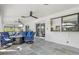 Comfortable outdoor patio with tile flooring, ceiling fans, and a modern fireplace with blue cushioned seating at 269 Mark Twain Ln, Rotonda West, FL 33947